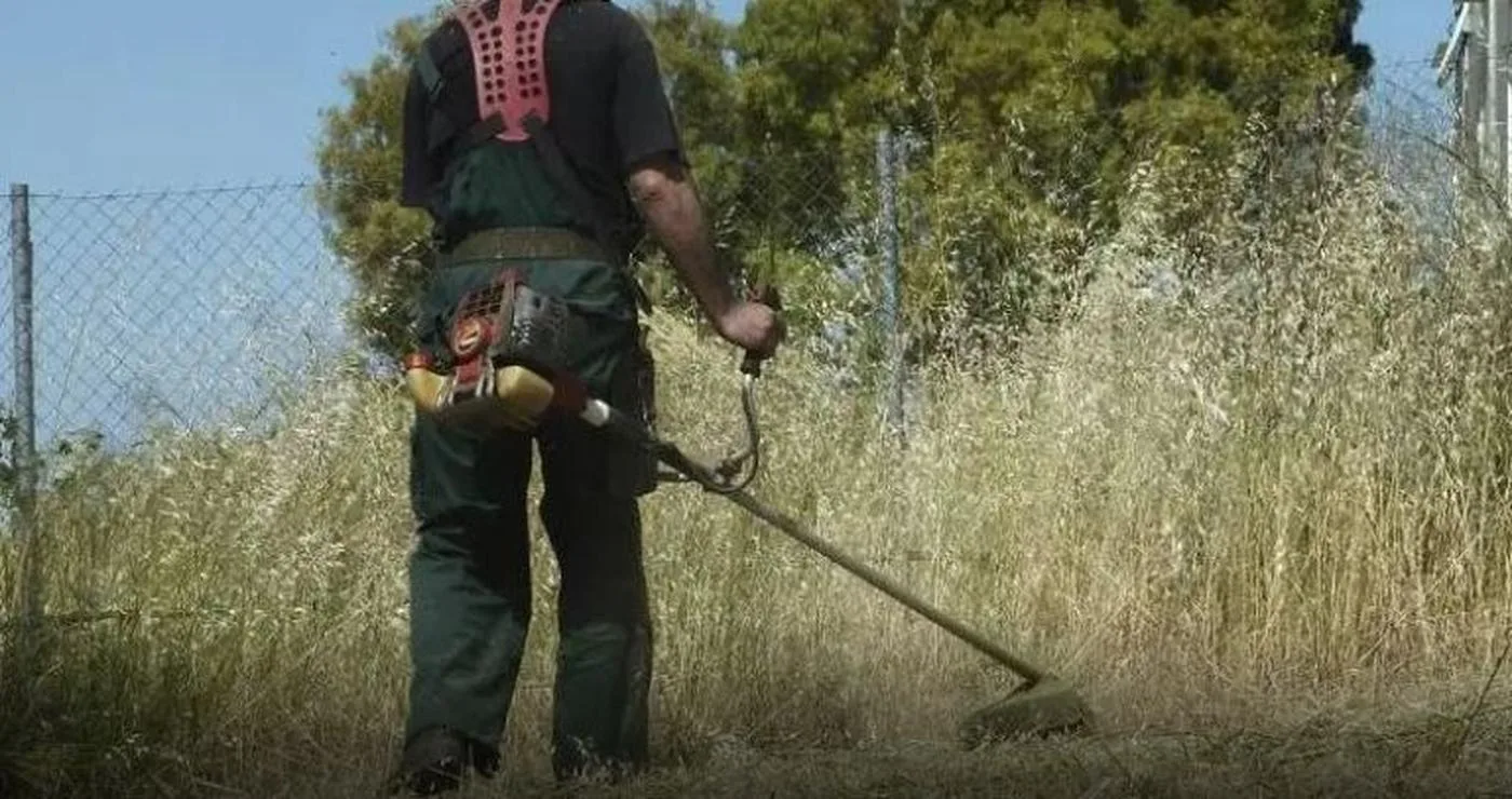 Ένας εργάτης χρησιμοποιεί ένα βενζινοκίνητο χορτοκοπτικό για τον καθαρισμό ενός οικοπέδου στη Φλώρινα, προετοιμάζοντας το για την αντιπυρική περίοδο 2026.