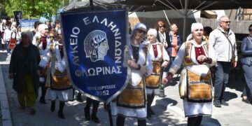 Μια ομάδα χορευτών του Λυκείου Ελληνίδων Φλώρινας περπατάει σε μια παραποτάμια περιοχή κατά τη διάρκεια της γιορτής του Χορός στη Φλώρινα.