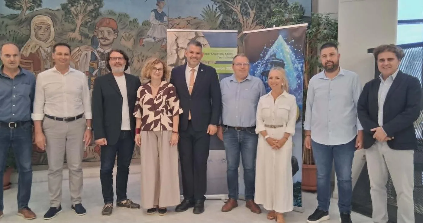Μια ομάδα ανθρώπων στέκεται μπροστά από έναν τοίχο με μια τοιχογραφία, αντιπροσωπεύοντας τον δήμο Φλώρινας και τα ποτάμια της περιοχής.