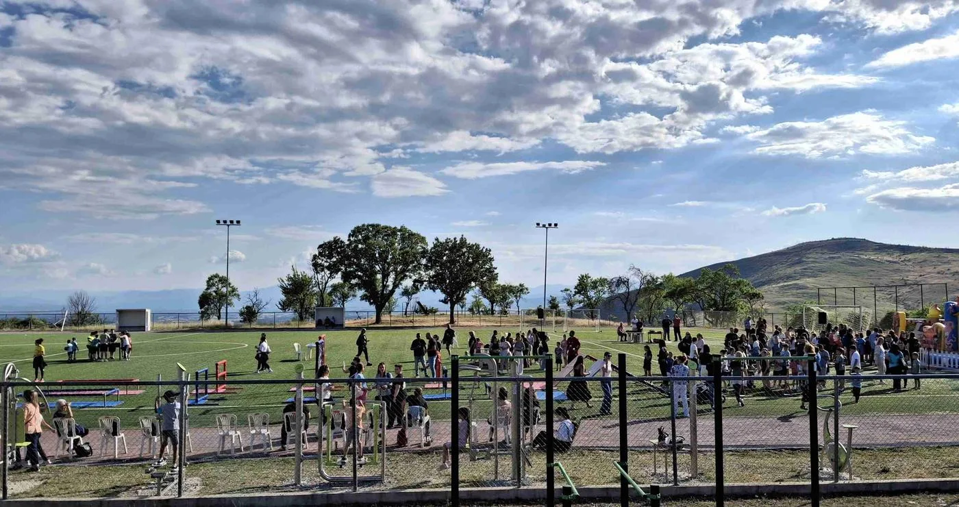 Παιδιά και γονείς διασκεδάζουν στο Welcome Summer Fest του Δήμου Βοΐου, σε ένα γήπεδο με φουσκωτά παιχνίδια και δραστηριότητες κάτω από έναν συννεφιασμένο ουρανό.