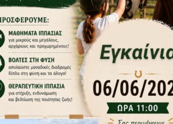 Ένα άλογο στέκεται δίπλα στην αφίσα για τα εγκαίνια του Ιππικού Κέντρου Σιάτιστας, ένα νέο σημείο αναφοράς για την περιοχή.