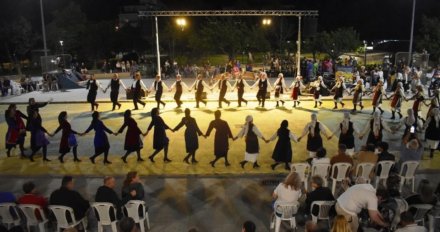 Χορευτές σχηματίζουν έναν μεγάλο κύκλο χορεύοντας στο Νέο Πάρκο της Φλώρινας κατά τη διάρκεια του Πολιτιστικού Καλοκαιριού 2026.
