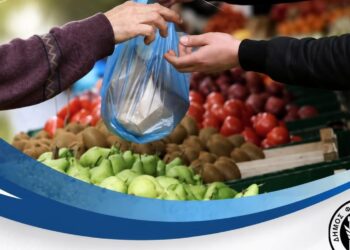 Ένα χέρι παραδίδει λαχανικά σε μια πλαστική σακούλα στην λαϊκή αγορά Φλώρινας.