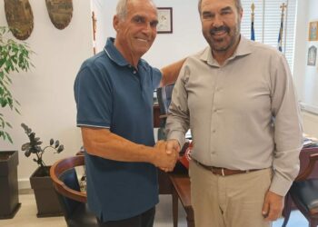 Δύο άνδρες ανταλλάσσουν χειραψία σε γραφείο, ο ένας εκ των οποίων είναι ο νέος αντιδήμαρχος Φλώρινας.