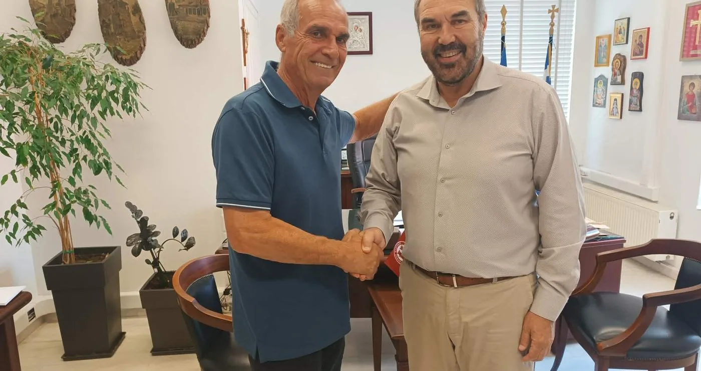 Δύο άνδρες ανταλλάσσουν χειραψία σε γραφείο, ο ένας εκ των οποίων είναι ο νέος αντιδήμαρχος Φλώρινας.