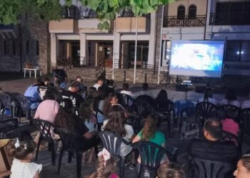 Ένα πλήθος ανθρώπων παρακολουθεί μια ταινία σε έναν θερινό κινηματογράφο στη Φλώρινα, απολαμβάνοντας μια καλοκαιρινή βραδιά.