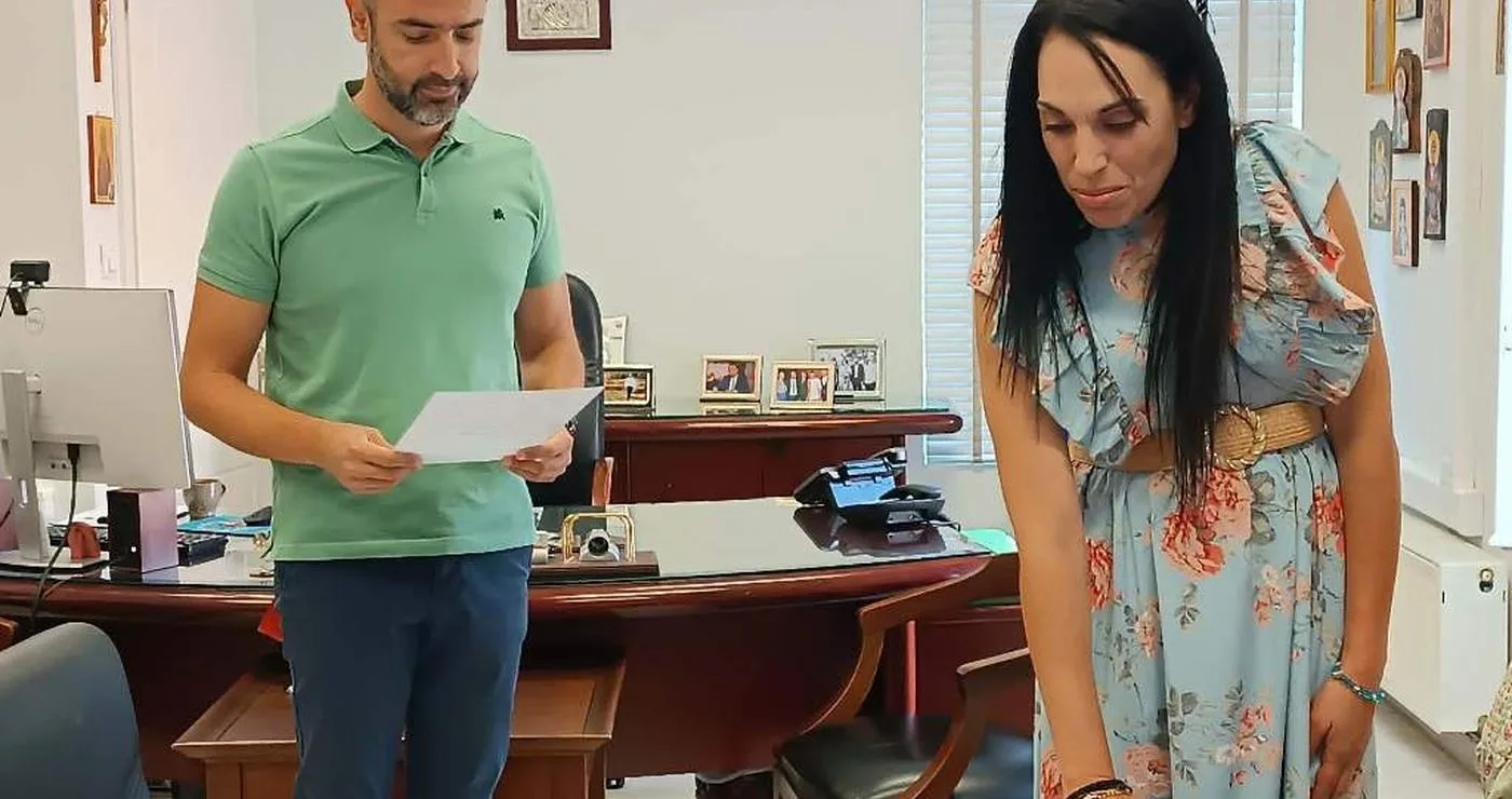 Ένας άνδρας και μια γυναίκα ορκίζονται στο γραφείο του Δημάρχου Φλώρινας, με την νέα υπάλληλο να τοποθετεί τα χέρια της πάνω σε ένα έγγραφο.