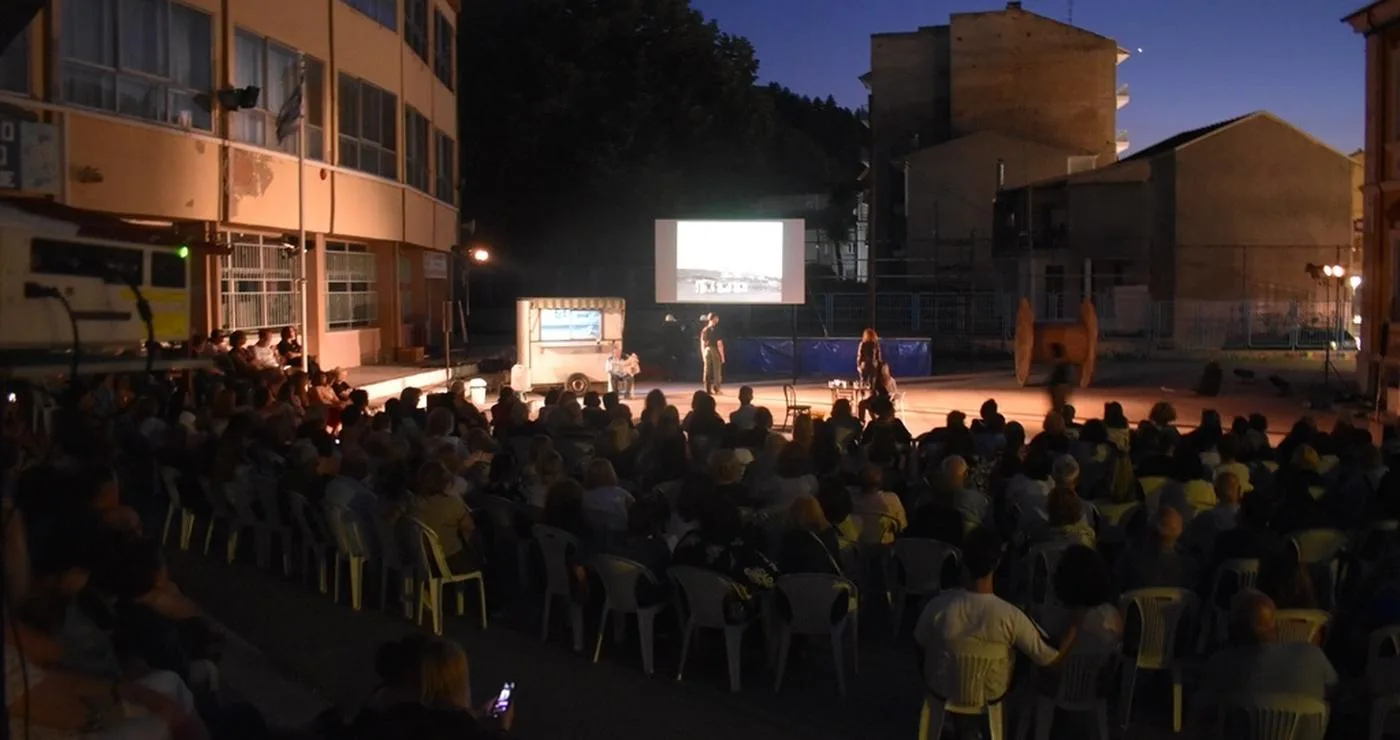 Το κοινό παρακολουθεί την παράσταση 'Γη της Επαγγελίας' στον αύλειο χώρο των 1ου – 2ου Δημοτικών Σχολείων στη Φλώρινα.