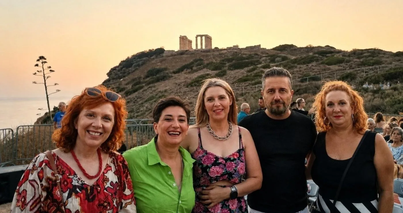 A group of five people smile for the camera with the Temple of Poseidon in Sounion visible in the background during the Κοζάνης - Λαυρεωτικής twinning event.