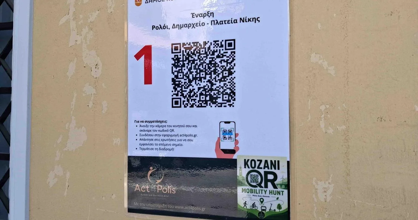 Ένα QR Code με τον αριθμό 1 είναι τοποθετημένο σε έναν πόλο στην πλατεία Νίκης στην Κοζάνη, μέρος του QR Mobility Hunt για την Ευρωπαϊκή Εβδομάδα Κινητικότητας.