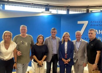 Έξι άτομα, οι Γραμματείς των Αποκεντρωμένων Διοικήσεων, στέκονται χαμογελαστοί στο περίπτερο των Αποκεντρωμένων Διοικήσεων στη ΔΕΘ.