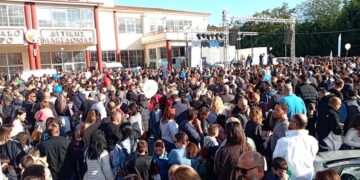 A large crowd of people gathers in front of the building hosting the Εμποροβιοτεχνική Έκθεση Δυτικής Μακεδονίας.