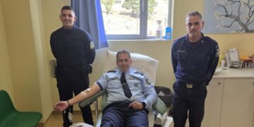 Τρεις αστυνομικοί στέκονται σε ένα νοσοκομειακό δωμάτιο, με έναν από αυτούς να δίνει αίμα στην αιμοδοσία Γρεβενών.