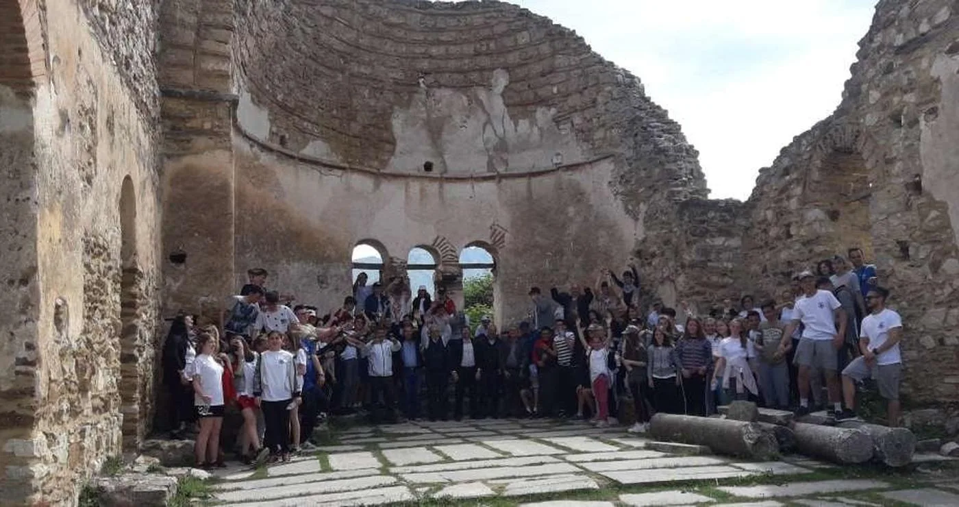 Μια ομάδα μαθητών στέκεται ομαδικά μέσα στην ερειπωμένη Βασιλική του Αγίου Αχιλλείου κατά τη διάρκεια των Σχολικών Αγώνων Πρεσπών.