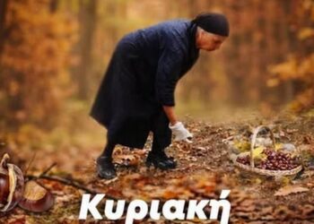 Ένας άνδρας στέκεται πάνω από ένα μεγάλο ταψί με ψημένους κάστανες στην καστανογιορτή Βοΐου, με κόσμο να απολαμβάνει την γιορτή.