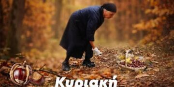 Ένας άνδρας στέκεται πάνω από ένα μεγάλο ταψί με ψημένους κάστανες στην καστανογιορτή Βοΐου, με κόσμο να απολαμβάνει την γιορτή.