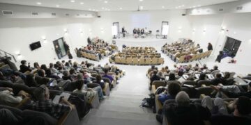 Μια αίθουσα διαλέξεων στο Πανεπιστήμιο Δυτικής Μακεδονίας είναι γεμάτη με άτομα που παρακολουθούν μια παρουσίαση σχετικά με την τεχνητή νοημοσύνη στην καρδιολογία.