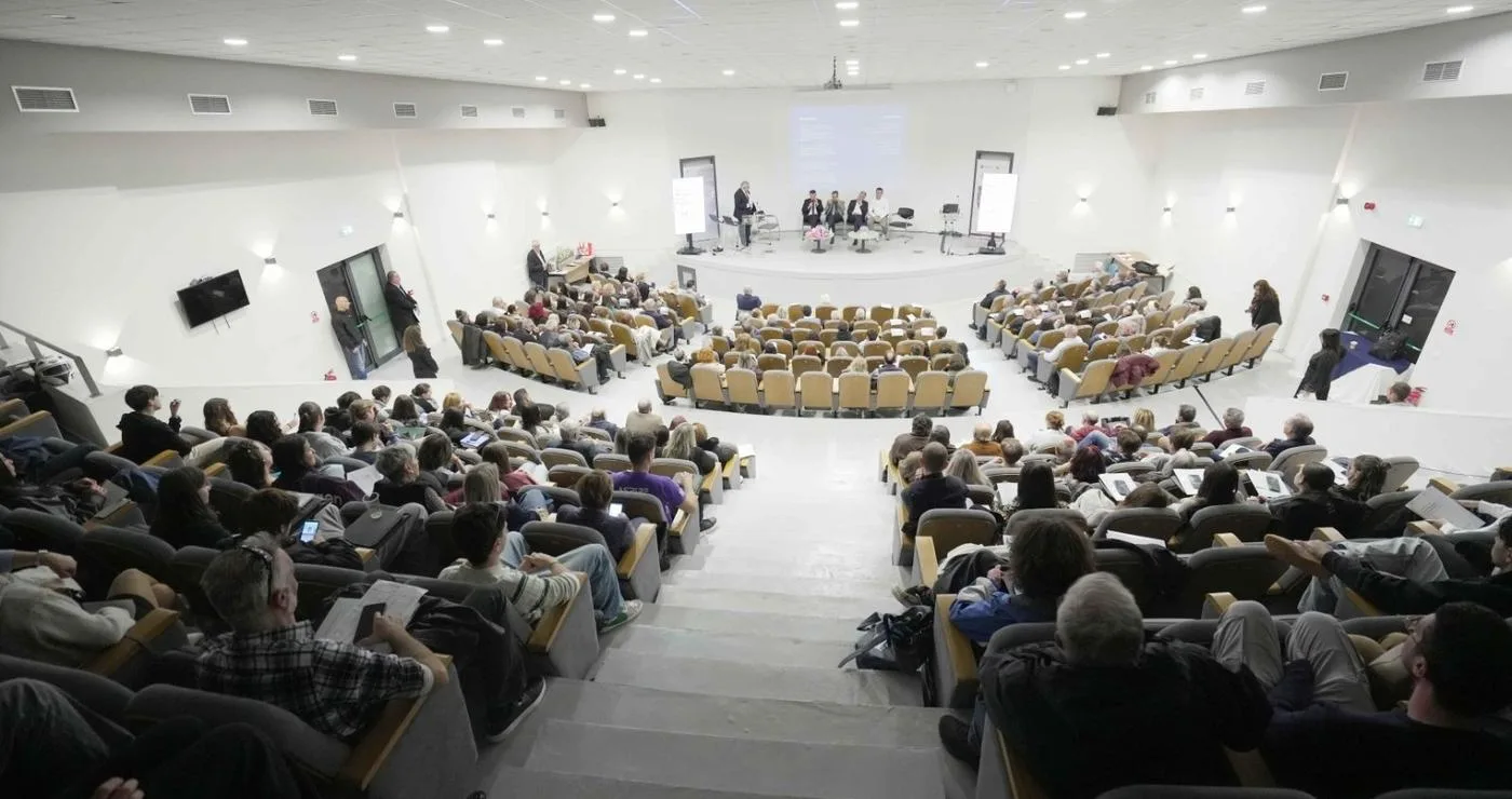 Μια αίθουσα διαλέξεων στο Πανεπιστήμιο Δυτικής Μακεδονίας είναι γεμάτη με άτομα που παρακολουθούν μια παρουσίαση σχετικά με την τεχνητή νοημοσύνη στην καρδιολογία.