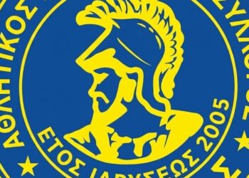 Το λογότυπο του Αία Αμυνταίου, που απεικονίζει τον Αία τον Αμυνταίο με κράνος, σε κυκλικό μπλε και κίτρινο σχέδιο, συμβολίζοντας την επιτυχημένη νίκη της ομάδας.