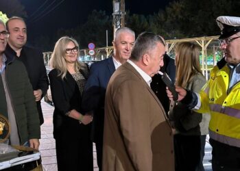 Μια ομάδα ανθρώπων στέκεται έξω από ένα wine-resto-bar στο Αμύνταιο, συμμετέχοντας στην «Ευρωπαϊκή Νύχτα χωρίς Ατυχήματα» και συζητώντας με έναν αστυνομικό.