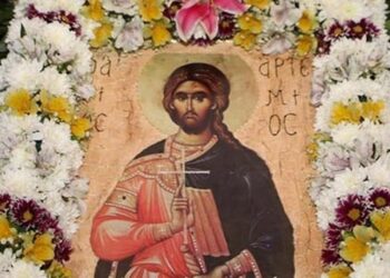 Η εικόνα του Αγίου Αρτεμίου, προστάτη της ελληνικής αστυνομίας, περιτριγυρισμένη από λουλούδια σε εορταστικό πλαίσιο.