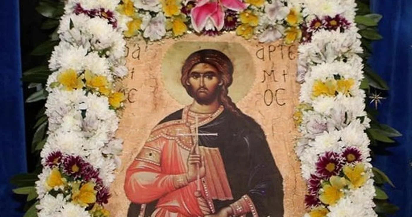 Η εικόνα του Αγίου Αρτεμίου, προστάτη της ελληνικής αστυνομίας, περιτριγυρισμένη από λουλούδια σε εορταστικό πλαίσιο.