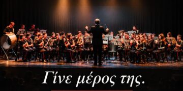 Μια ορχήστρα της Φιλαρμονικής Κοζάνης ερμηνεύει μουσική σε μια σκηνή, ενώ νέα μέλη εγγράφονται για να γίνουν μέρος της ορχήστρας Φιλαρμονική Κοζάνης.